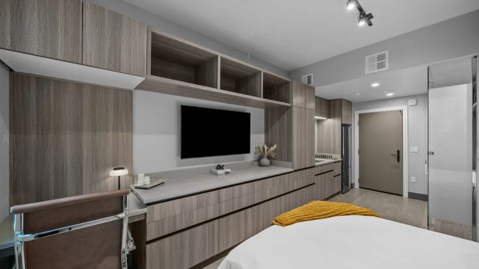 Furnished studio apartment at Salt Lake Crossing with built in shelves and TV.