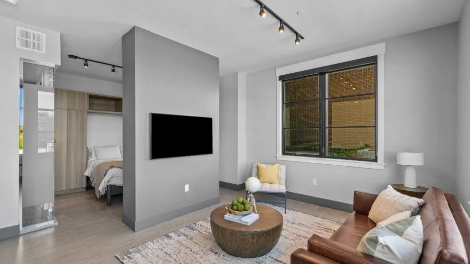 Open one bedroom apartment at Salt Lake Crossing with living room and wall mounted TV.