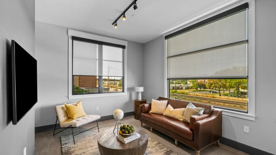 Open one bedroom apartment at Salt Lake Crossing with plush seating and large windows.