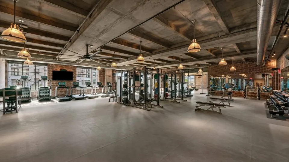 Salt Lake Crossing fitness center with cardio machines, weight equipment, and large windows.