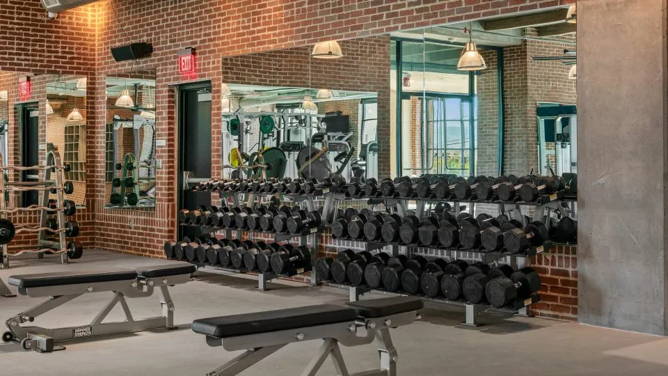 Salt Lake Crossing fitness center with weight equipment and large mirrors.
