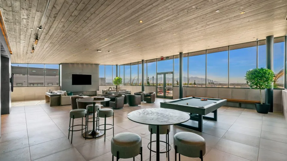 Salt Lake Crossing lounge with plush seating, billiards table, wall mounted TV and panoramic views.