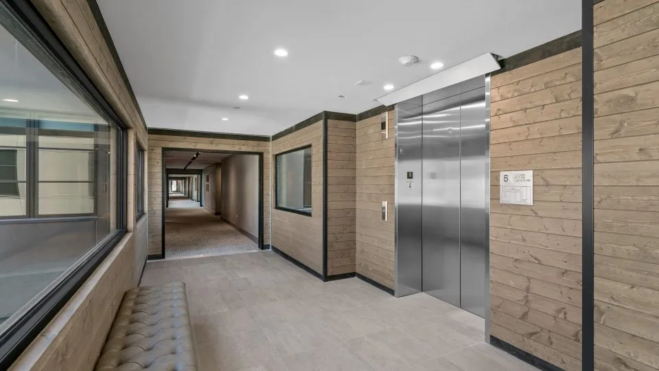 Hallway at Salt Lake Crossing with elevators and large windows.