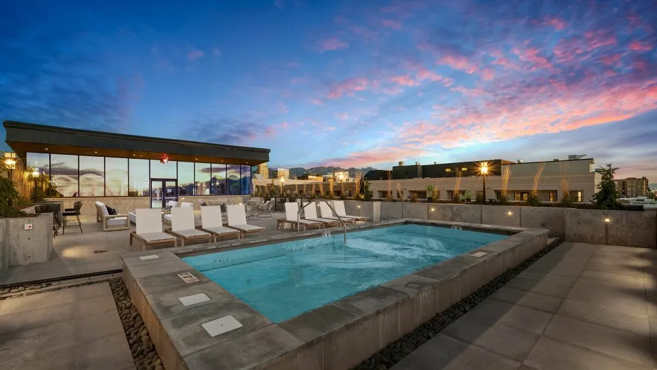 Salt Lake Crossing rooftop pool with lounge chairs at dusk.