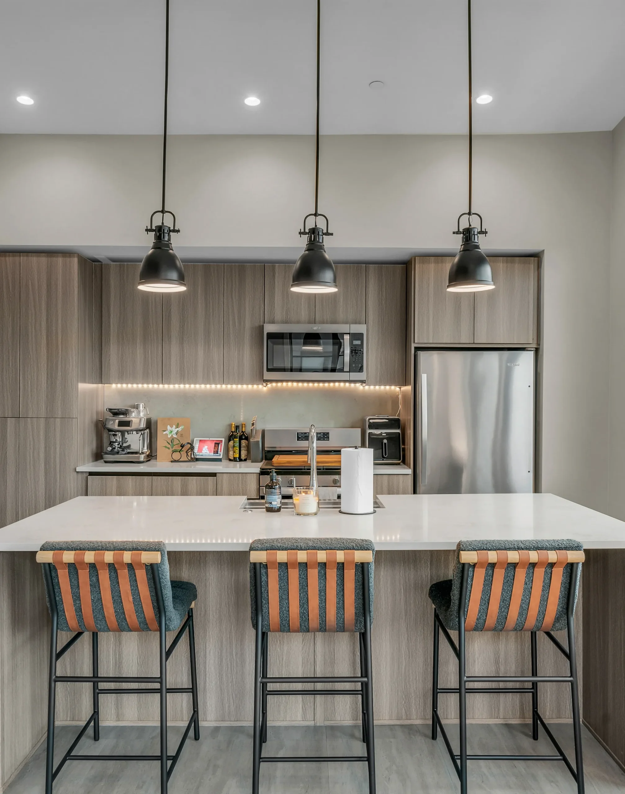Apartment kitchen with breakfast bar and pendant lights at Salt Lake Crossing.