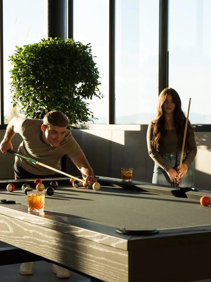 Friends playing pool together at the Salt Lake Crossing billiards table.