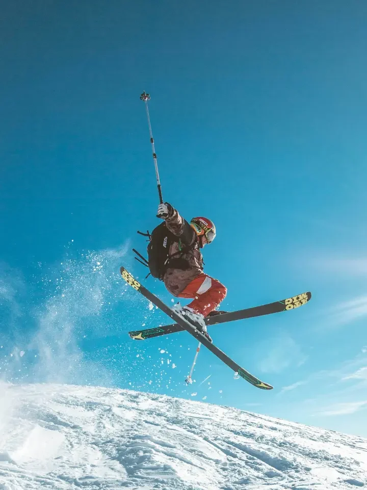 Person jumping on skis in snowy Utah mountains.